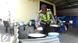Anggota Polwan mempersiapkan bahan makan siang untuk para anggota kepolisian yang bertugas di pos pengamanan 06 exit tol Brebes Timur, Jawa Tengah, Sabtu (9/7). (Liputan6.com/Herman Zakharia)