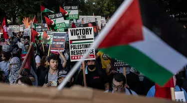 Orang-orang memegang plakat dan melambaikan bendera Palestina dalam sebuah protes pro-Palestina saat Konvensi Nasional Partai Demokrat (DNC) berlangsung di Chicago, Illinois, pada 22 Agustus 2024. (CHRISTIAN MONTERROSA/AFP)