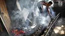 Sejumlah pekerja membakar lemang di Kawasan Senen, Jakarta, Selasa (30/5). Selama Ramadan, permintaan makanan berbahan ketan khas Sumatera ini menjadi makanan favorit warga untuk sajian berbuka puasa. (Liputan6.com/Immanuel Antonius)