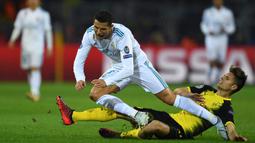 Bintang Real Madrid, Cristiano Ronaldo, dijatuhkan bek Dortmund, Lukasz Piszczek, pada laga Liga Champions di Stadion Signal Iduna Park, Dortmund, Selasa (26/9/2017). Dortmund kalah 1-3 dari Madrid. (AFP/Patrik Stollarz)