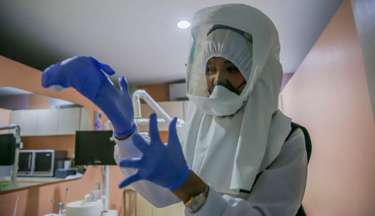 Dr. Maureen P. Ines-Manzano, seorang dokter gigi, mengenakan setelan respirator dengan pemurni udara di dalam kliniknya di Manila, Filipina, pada 19 Oktober 2020. Pasien Dr. Manzano menjulukinya "dokter gigi astronaut" karena mengenakan setelan PAPR utuk menghindari COVID-19. (Xinhua/Rouelle Umali)