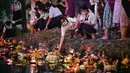 Orang-orang melepaskan lampion mengambang di kolam selama festival Loy Krathong di Bangkok (8/11/2022). Penghormatan tersebut dilakukan dengan cara melepaskan teratai yang dihiasi dengan lilin, dupa dan bunga ke air. (AFP/Lillian Suwanrumpha)