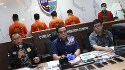 Kasubdit I Tindak Pidana Siber Bareskrim Polri Kombes (Pol) Dani Kustoni (kiri) didampingi Kabag Penum Divisi Humas Polri Kombes Asep Adi Saputra (tengah) menunjukkan tersangka beserta barang bukti kasus tindak pidana hacking server Indomaret di Jakarta, Jumat (12/4). (Liputan6.com/ImmanuelAntonius)