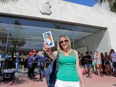 Ana Melchiors, dari Brazil, menunjukkan iPhone X setelah ia membelinya di Miami Beach, Florida (3/11). iPhone X mulai dijual pada hari Jumat (10/11/2017). (AP Photo/Alan Diaz)