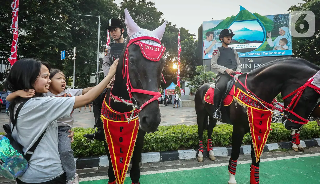 Warga menyentuh kuda yang ditunggangi polisi saat mengamankan CFD. (Liputan6.com/Faizal Fanani)