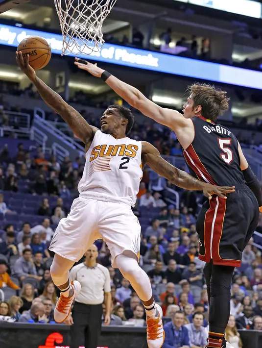 Pemain Phoenix Suns, Eric Bledsoe (2) melewati hadangan pemain Miami Heat, Luke Babbitt (5) saat melakukan lay up pada laga NBA basketball game, (3/1/2017) di US Airways Center, Phoenix.  Suns menang 99-90. (AP/Ross D. Franklin)