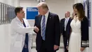 Presiden AS Donald Trump (tengah) berjabat tangan dengan dokter Igor Nichiporenko (kiri) saat mengunjungi rumah sakit Broward Health North Pompano Beach, Florida (16/2). (AFP Photo/Jim Watson)