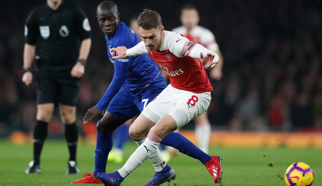 Gelandang Arsenal, Aaron Ramsey berebut bola dengan gelandang Chelsea, N'Golo Kante selama pertandingan lanjutan Liga Inggris di stadion Emirates di London (19/1). Arsenal menang 2-0 atas Chelsea. (AP Photo/Frank Augstein)