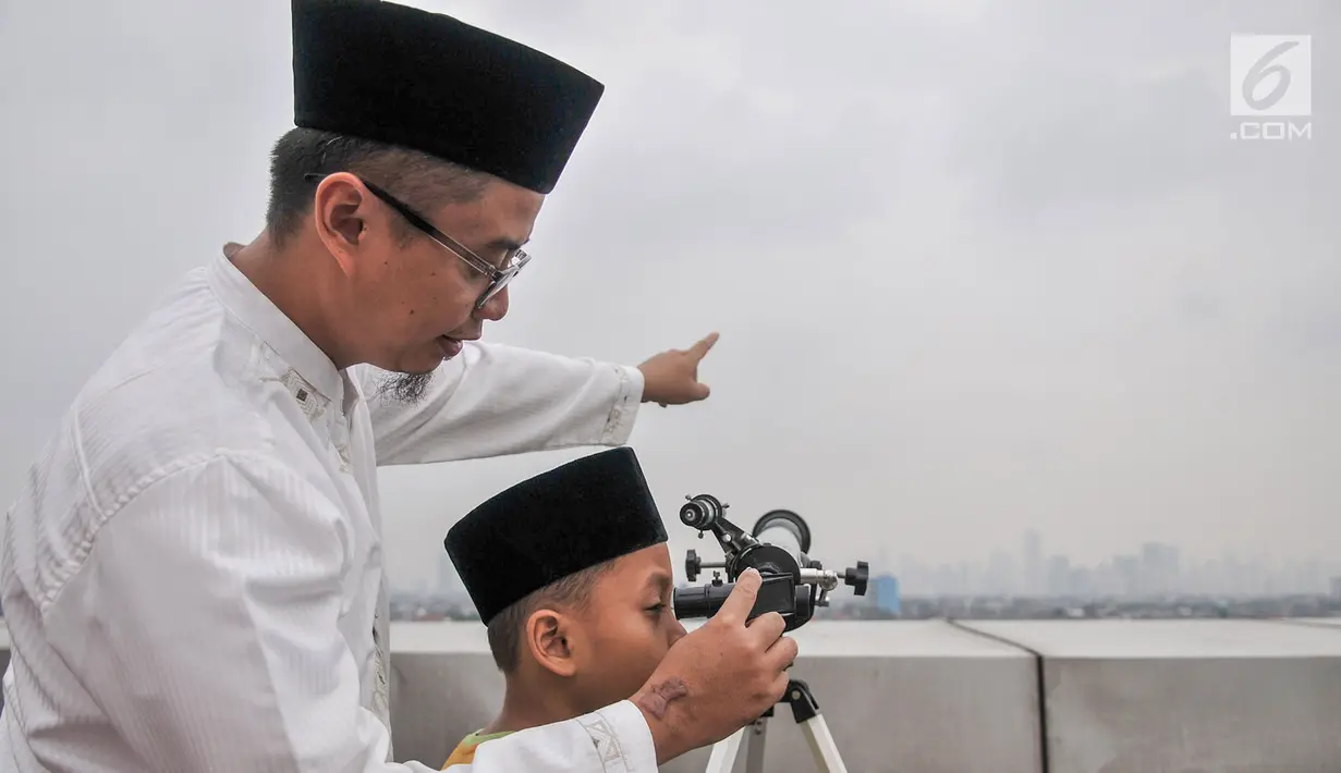 Tim hisab rukyat Kanwil Kemenag DKI Jakarta memantau hilal menggunakan teleskop di atap Gedung Kanwil Kemenag DKI Jakarta, Senin (03/6/2019). Berdasarkan fatwa MUI, posisi hilal baru bisa ditentukan apabila berada pada titik 2 derajat di atas ufuk. (merdeka.com/Iqbal S Nugroho)