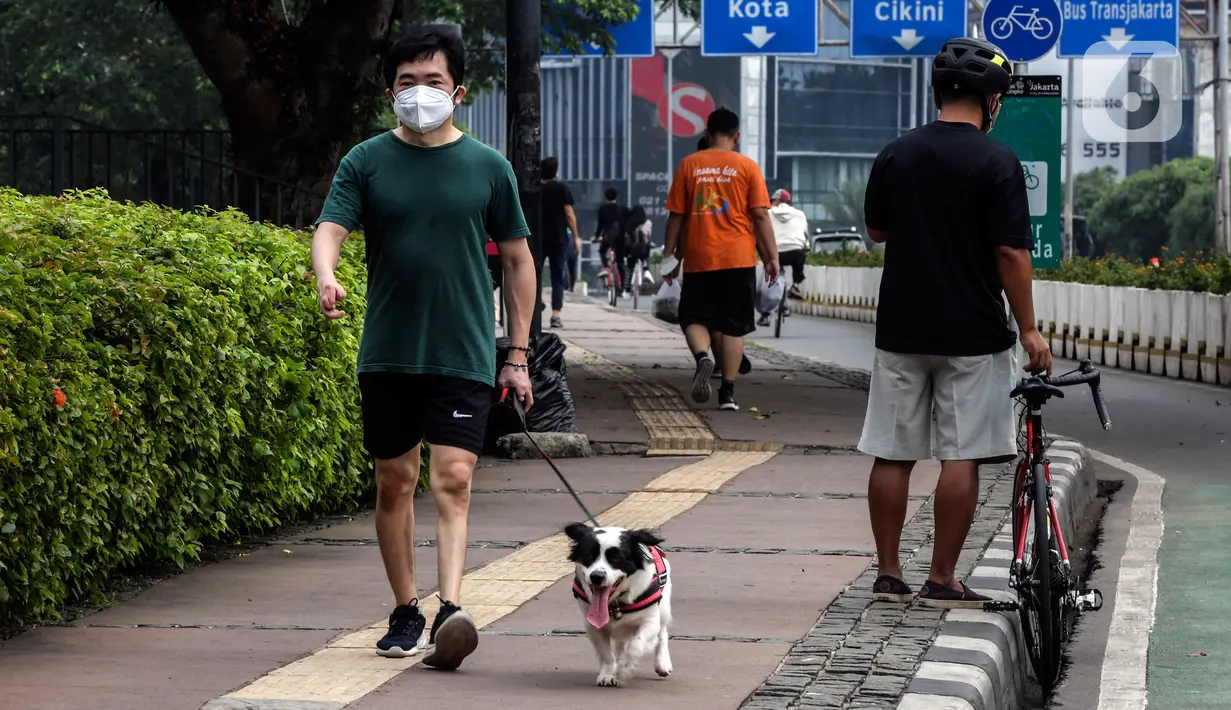 Warga membawa anjingnya saat berolahraga pada akhir pekan di kawasan Sudirman - Thamrin, Jakarta, Minggu (20/2/2022). Aktivitas warga di kawasan tersebut relatif ramai saat Pemberlakuan Pembatasan Kegiatan Masyarakat (PPKM) level tiga di ibu kota. (Liputan6.com/Johan Tallo)