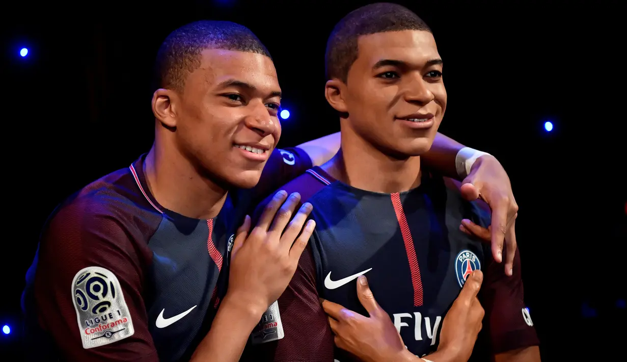 Striker PSG, Kylian Mbappe, berpose dengan patung lilinnya di Museum Grevin, Paris, Kamis (17/5/2018). Patung ini merupakan apresiasi karena keberhasilannya meraih gelar pemain muda terbaik dan trofi Liga Prancis. (AFP/Christophe Simon)
