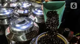 Pekerja memperlihatkan biji kopi dagangannya di salah satu gerai kopi di kawasan Jakarta, Rabu (24/3/2021). Tahun ini pemerintah menargetkan produksi kopi nasional sebesar 834.750 ton, naik dari tahun lalu sebanyak 769,7 ribu ton. (Liputan6.com/Johan Tallo)