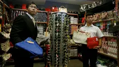 Petugas memperlihatkan sejumlah barang palsu di Kantor Bea Cukai Hong Kong, Kamis (6/8). Lebih dari 30.000 barang disita dari satu warga Filipina dan dua warga Pakistan yang merupakan sindikat penjual barang yang diduga palsu. (REUTERS/Bobby Yip)