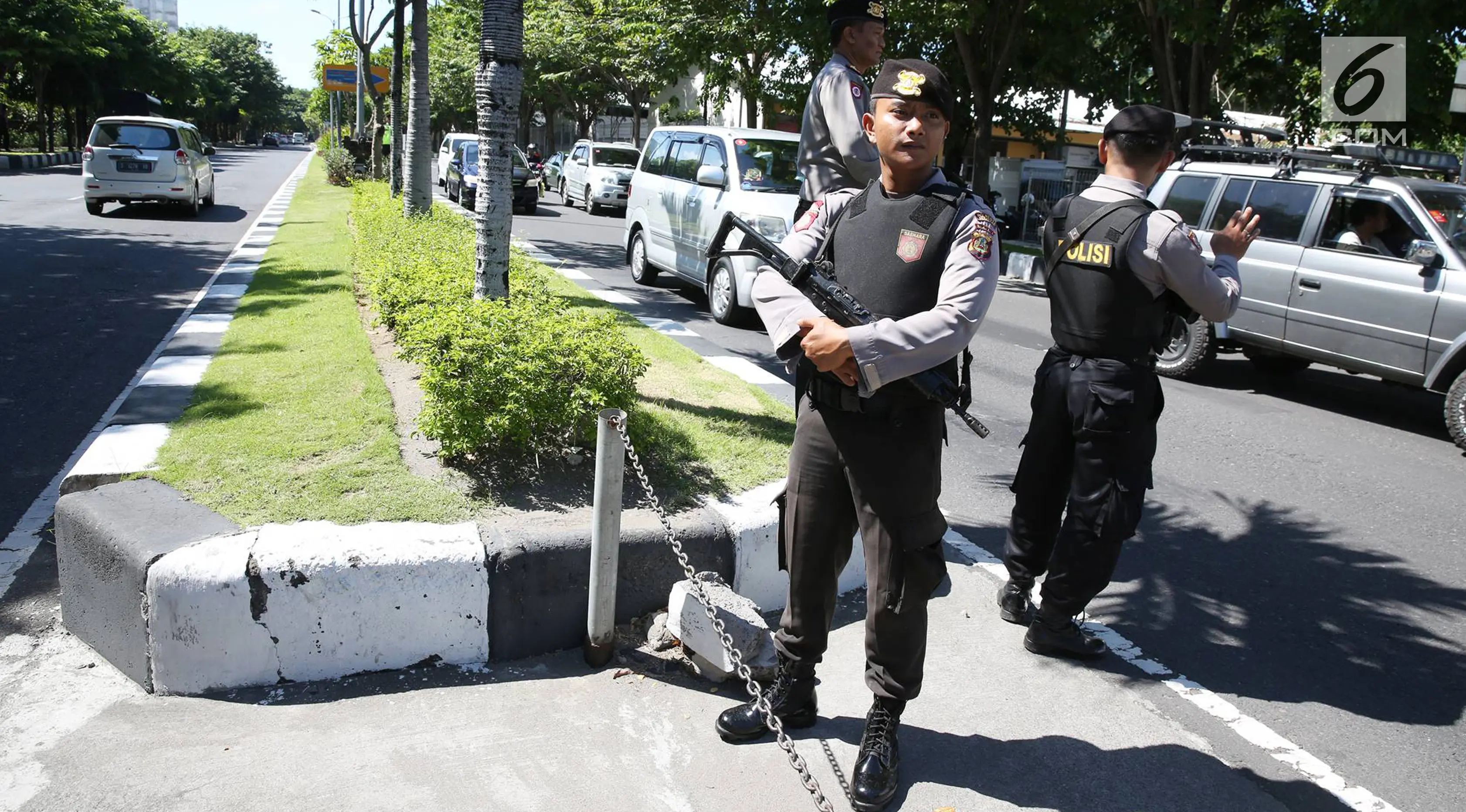 Petugas kepolisian bersiaga di sepanjang jalur yang dilalui rombongan Barack Obama menuju Base Ops Lanud Ngurah Rai, Bali, Rabu (28/6). Obama dan keluarga meninggalkan Bali untuk melanjutkan liburan ke Yogyakarta. (Liputan6.com/Immanuel Antonius) 