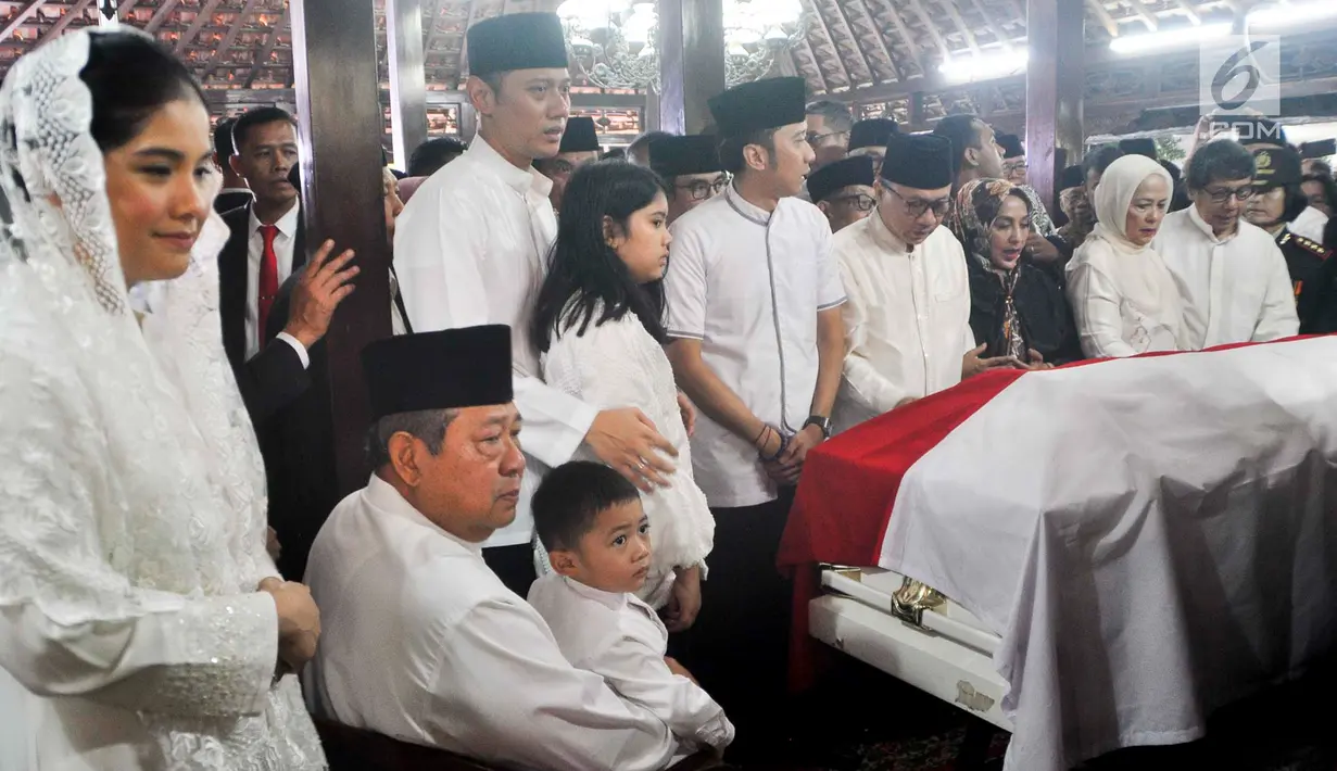 Presiden ke-6 RI Susilo Bambang Yudhoyono (duduk) bersama anaknya Agus Harimurti Yudhoyono dan Edhie Baskoro Yudhoyono berada di dekat peti jenazah Ani Yudhoyono di Puri Cikeas, Bogor, Jawa Barat, Minggu (2/6/2019). (Liputan6.com/Immanuel Antonius)