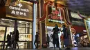 Orang-orang berjalan melewati dekorasi lampu Natal di luar pusat perbelanjaan di sepanjang kawasan Orchard road di Singapura, Selasa (8/12/2020). Mengusung tema Love This Christmas, acara tahun ini lebih sunyi karena aktivitas jalanan dibatasi di tengah pandemi Covid-19. (ROSLAN RAHMAN / AFP)