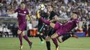 Bek Manchester City, Nicolas Otamendi, membuang bola dari jangkauan gelandang Real Madrid, Gareth Bale, pada laga ICC di Stadion Memorial Coliseum, California, Rabu (26/7/2017). Manchester City menang 4-1 atas Real Madrid. (AP/Jae C Hong)