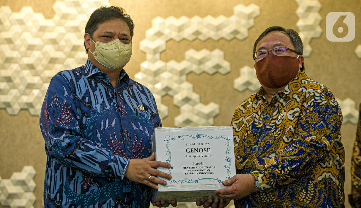 Menristek Bambang Brodjonegoro (kanan) memberikan GeNose C19 kepada Menko Bidang Perekonomian Airlangga Hartarto di Gedung Kemenko Perekonomian, Jakarta, Senin (22/3/2021). GeNose C19 diharapkan dapat semakin dikenal dan dimanfaatkan secara lebih masif. (Liputan6.com/Faizal Fanani)