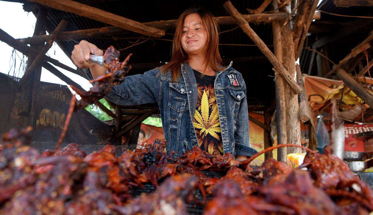 Pedagang memanggang tikus untuk dijual di provinsi Battambang (8/8/2019). Tikus bakar bukanlah makanan yang lezat untuk dinikmati, tetapi di provinsi pedesaan Battambang, Kamboja, mereka populer sebagai camilan murah. (AFP Photo/Tang Chhin Sotthy)