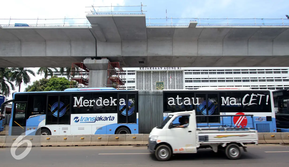 Sebuah mobil melintas di sebelah bus Transjakarta di Terminal Blok M, Jakarta Selatan, Kamis (12/1). PT Transjakarta tambah 2.000 unit bus, sehingga pada akhir tahun 2017 jumlah bus yang dimiliki bisa mencapai 3.300 unit. (Liputan6.com/Gempur M. Surya)