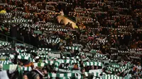 Aksi suporter Celtic saat menjamu Barcelona pada laga kelima Grup C Liga Champions di Celtic Park, Rabu (23/11/2016). (AFP/Paul Ellis)