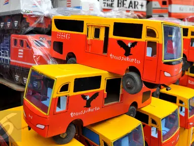 Sejumlah mobil mainan berupa bus Transjakarta yang terbuat dari kayu terpajang di kios penjual mainan di kawasan Pasar Minggu, Jakarta, Selasa (3/11). Membanjirnya mainan anak asal China mengancam produksi mainan dalam negeri (Liputan6.com/Gempur M Surya)