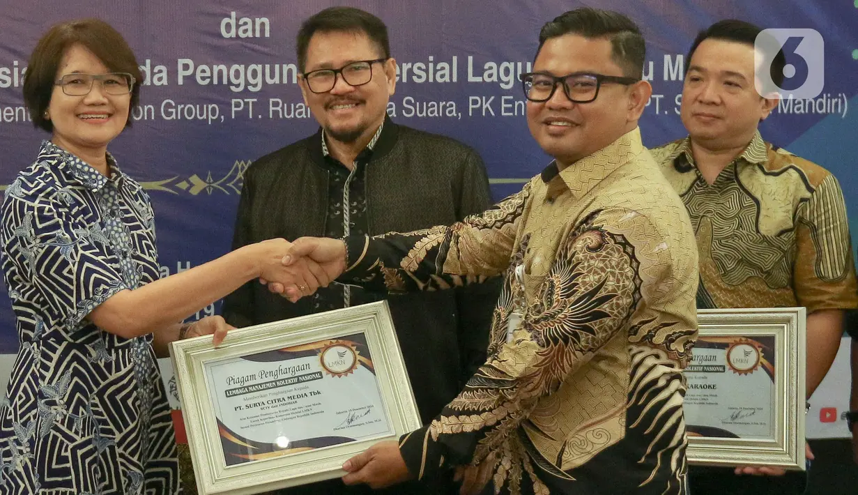 Head of Protocol & Corporate Affairs Surya Citra Media (SCM), Irnawati W Kahardja (kiri) menerima apresiasi kepada pengguna komerisal dari Lembaga Manajemen Kolektif Nasional (LMKN) di kawasan Kuningan, Jakarta, Kamis (19/12/2024). (Liputan6.com/Herman Zakharia)