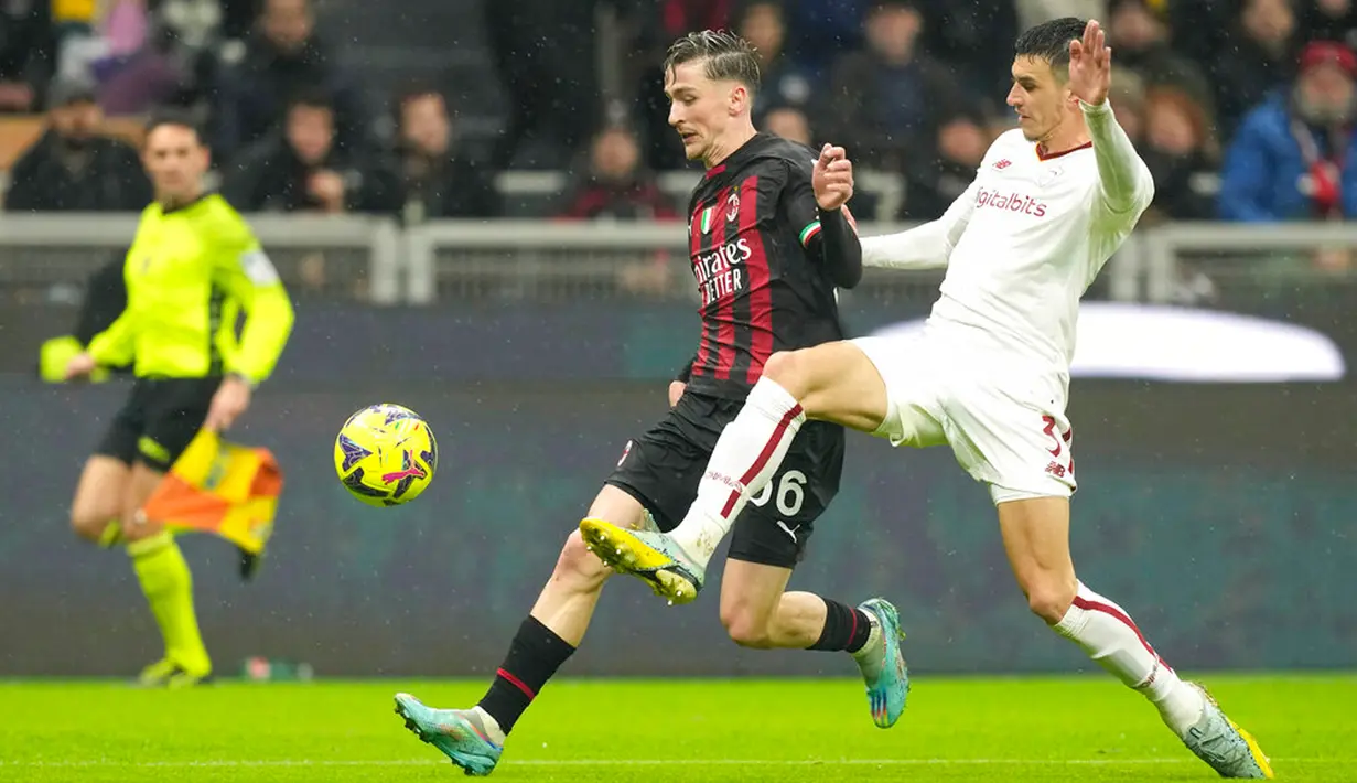 Pemain AC Milan Alexis Saelemaekers (tengah) berebut bola dengan pemain AS Roma Roger Ibanez pada pertandingan sepak bola Serie A Liga Italia di Stadion San Siro, Milan, Italia, 8 Januari 2023. Pertandingan berakhir imbang 2-2. (AP Photo/Antonio Calanni)