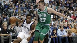 Pemain Dallas Mavericks, Yogi Ferrell (11) menggiring bola melewati adangan pemain Boston Celtics, Daniel Theis (27) pada laga NBA basketball game di American Airlines Center, Dallas, (20/11/2017).   Celtics menang 110-102. (AP/Tony Gutierrez)