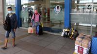 Penumpang berjalan di Terminal Terpadu Pulo Gebang, Jakarta, Kamis (11/2/2021). Berdasarkan data Dishub hingga pukul 14.00 WIB, Terminal Terpadu Pulo Gebang telah memberangkatkan 466 pemudik menuju luar Jakarta. (Liputan6.com/Herman Zakharia)