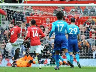 Pemain Manchester United Paul Pogba berhasil mencetak gol ke gawang Arsenal saat pertandingan Liga Inggris di stadion Old Trafford di Manchester (29/4). Manchester United mengalahkan Arsenal 2-1 pada pekan ke-36 Premier League. (AP Photo / Rui Vieira)