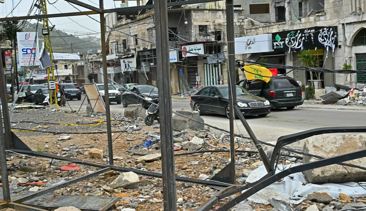 Mereka kembali setelah gencatan senjata sementara selama 10 hari diberlakukan antara Lebanon dan Israel. Tampak dalam foto, warga pengungsi berkendara melewati bangunan-bangunan yang hancur saat mereka kembali ke kota Nabatieh, Lebanon Selatan pada Sabtu 18 April 2026. (FADEL itani/AFP)