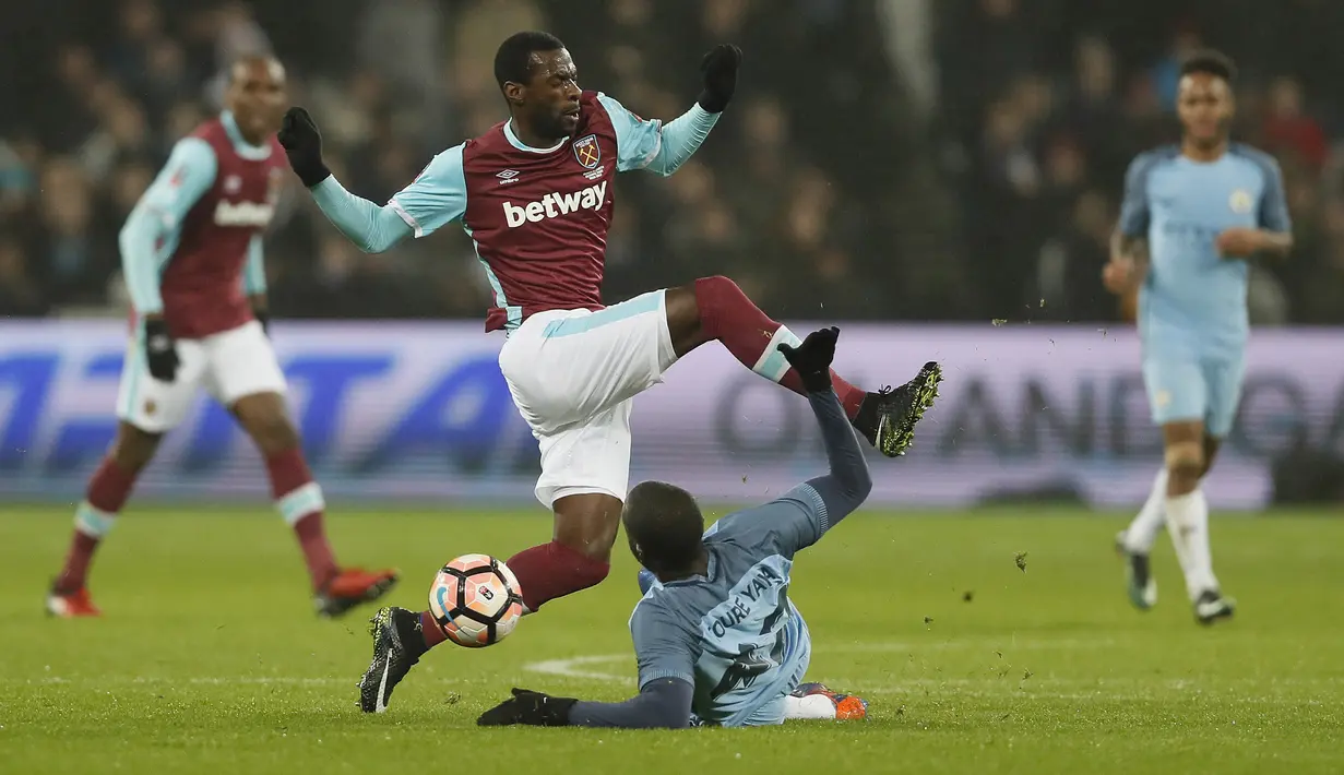 Aksi pemain West Ham, Pedro Obiang  menghindari terjangan pemain Manchester City, Yaya Toure pada laga Piala FA di London stadium, (6/1/2017). City menang 5-0. (AP/Kirsty Wigglesworth)