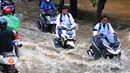 Sejumlah pengendara motor melintasi banjir di Jalan Benteng,  Duta Kranji, Kalibaru, Bekasi, Jawa Barat, Jumat (24/2/2023). Hujan yang turun di Bekasi sejak Kamis malam mengakibatkan sejumlah wilayah di Bekasi tergenang hingga lebih dari 50 cm. (merdeka.com/Imam Buhori)