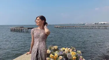 Berlatar laut lepas, Mikaila Patritz terlihat cantik paripurna dalam balutan kebaya dengan konsep dres panjang. Warna kebaya yang dikenakan ibu satu anak itu terlihat match dengan dekorasi bunga. (Liputan6.com /IG/@mikailapatritz).