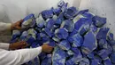 Pedagang menunjukkan tumpukan batu Lapis Lazuli yang dijual di Kabul, Afghanistan (5/6). Batu lapis lazuli  ini telah ditambang dari provinsi Badakhshan, Afganistan selama lebih dari 6.000 tahun. (REUTERS/Mohammad Ismail)