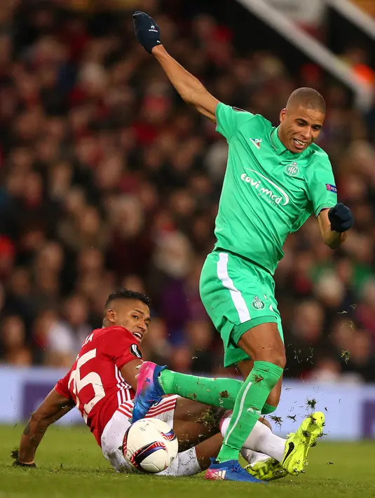Bek Manchester United, Antonio Valencia berusaha merebut bola pemain Kevin Monnet-Paquet saat bertanding di Liga Eropa di Olad Trafford, Inggris, (16/2). MU menang telak atas Saint-Etienne 3-0. (AFP Photo / Oli Scarff)