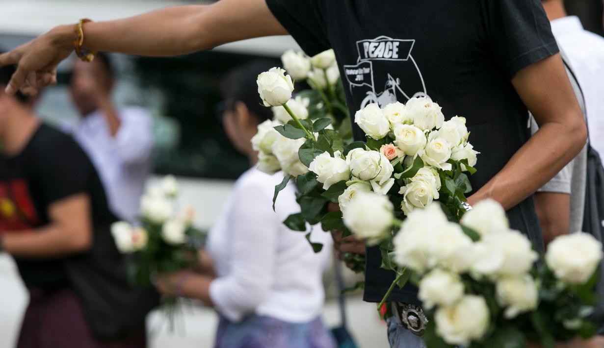 Umat Buddha Myanmar memberikan mawar putih kepada umat Islam yang akan melaksanakan salat Id pada perayaaan Idul Fitri di kota Than Lyin, pinggiran Yangon, Rabu (5/6/2019). Momen ini menjadi sebuah aksi solidaritas yang langka di sebuah negara, di mana Islam kerap difitnah.  (Sai Aung MAIN/AFP)