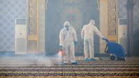 Pekerja mengenakan APD melakukan semprotan desinfektan di sebuah masjid di Bandar Seri Begawan, Brunei. (AFP)
