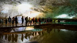 Pengunjung berjalan menyusuri gua alam Choranche, di wilayah Vercors dekat Grenoble, Prancis (3/8). Selain mencari situs alam yang indah, pengunjung juga mencari kesegaran bawah tanah dengan suhu sekitar 15 derajat celcius. (AFP Photo/Jean-Pierre Clatot)