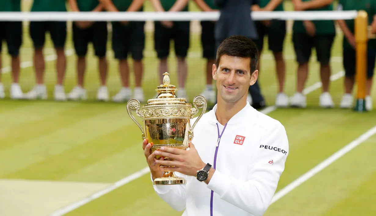 Petenis Serbia, Novak Djokovic menunjukkan trofi kemenangannya setelah mengalahkan petenis Swiss, Roger Federer di babak final tunggal putra Wimbledon 2015, London, Minggu (12/7). Ini adalah gelar Wimbledon ketiga bagi Djokovic.  (REUTERS/Stefan Wermuth)