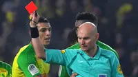 Wasit Tony Chapron (kanan) memberikan kartu merah kepada pemain Nantes, Diego Carlos, pada laga kontra Paris Saint-Germain di Stade de la Beaujoire - Louis Fonteneau, Nantes, Minggu (14/1/2018). (AFP/Loic Venance)