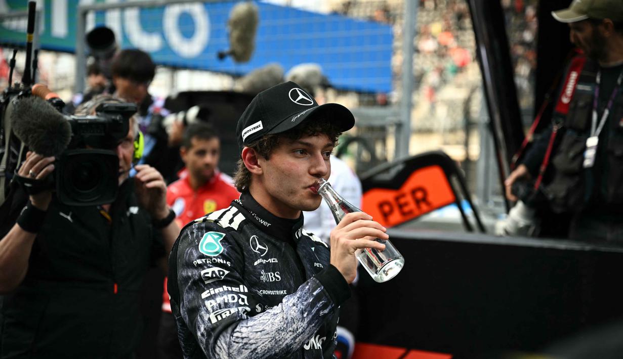 28.778 dalam sesi kualifikasi yang digelar di Sirkuit Suzuka, pada Sabtu (28/3/2026). Tampak dalam foto, pembalap Mercedes AMG Petronas asal Italia, Kimi Antonelli, minum air setelah meraih pole position pada sesi kualifikasi Formula 1 GP Jepang 2026 di Sirkuit Suzuka, pada Sabtu (28/3/2026). (Philip FONG/AFP)