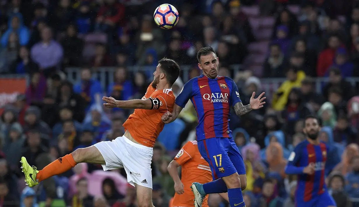 Striker Barcelona, Paco Alcacer, duel udara dengan bek Osasuna, Oier,  pada laga La Liga di Stadion Camp Nou, Barcelona, Rabu (26/4/2017). Barcelona menang 7-1 atas Osasuna. (AFP/Lluis Gene)
