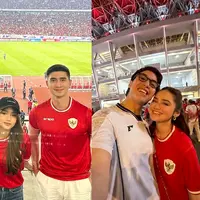 Maudy Effrosina memilih jersey Timnas warna putih, sementara Fadly Faisal tampil dengan jersey lengan panjang merah yang ia padukan dengan celana jeans. Kombinasi simpel namun tetap stylish ini menambah daya tarik keduanya di tengah euforia pertandingan.