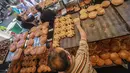 Pedagang menata kue-kue dagangannya saat berjualan di sebuah pasar di Ibu Kota Damaskus, Suriah, Minggu (19/5/2019). Perang sipil yang berlangsung selama delapan tahun terakhir membuat warga Suriah harus berhemat saat Ramadan. (Louai Beshara/AFP)