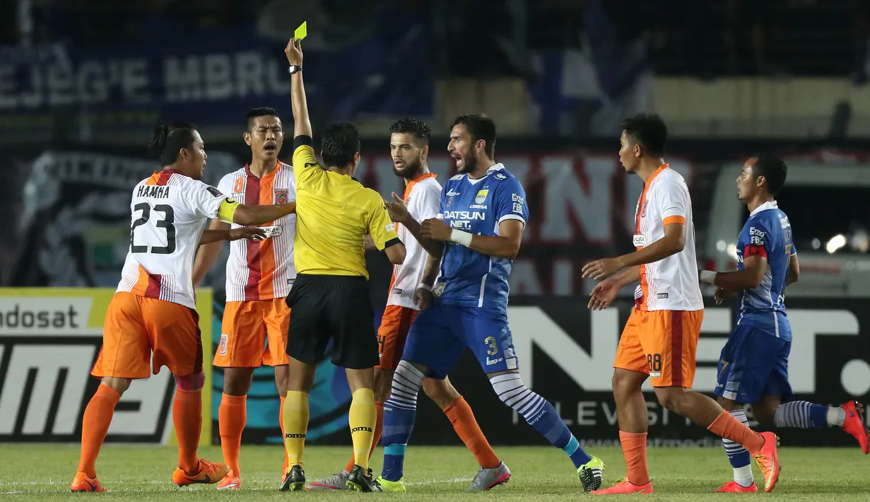 Wasit memberikan kartu kuning kepada pemain Pusamania Borneo FC, Jajang Mulyana dalam laga leg kedua perempatfinal Piala Presiden 2015 di Stadion Si Jalak Harupat, Bandung, Sabtu (26/9/2015). (Bola.com/Arief Bagus)