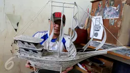 Seorang warga binaan menunjukan kapal pinishi yang terbuat dari lintingan koran di Lapas Kelas 1 Tangerang, Kota Tangerang.(29/10). Bahan yang dipergunakan yaitu koran bekas, lem kertas, dan kayu atau papan pendukung. (Liputan6.com/Fery Pradolo)
