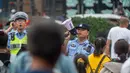 Polisi memandu pengunjung yang datang untuk menyaksikan gelombang pasang Sungai Qiantang di Hangzhou, Zhejiang, China, 4 Oktober 2020. Gelombang pasang Sungai Qiantang terjadi bertepatan dengan libur Hari Nasional dan Festival Pertengahan Musim Gugur tahun ini. (Xinhua/Jiang Han)