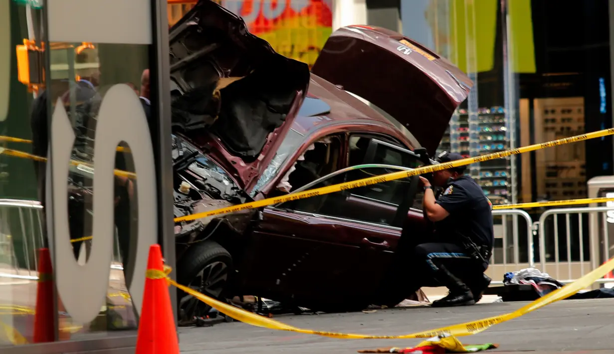 Petugas memotret kondisi mobil yang menabrak para pejalan kaki di trotoar Times Square, New York, Kamis (18/5). Para saksi mata menyebut mobil itu melaju melawan arus sebelum menabrak para pejalan kaki hingga melukai sekitar 22 orang. (Jewel SAMAD/AFP)